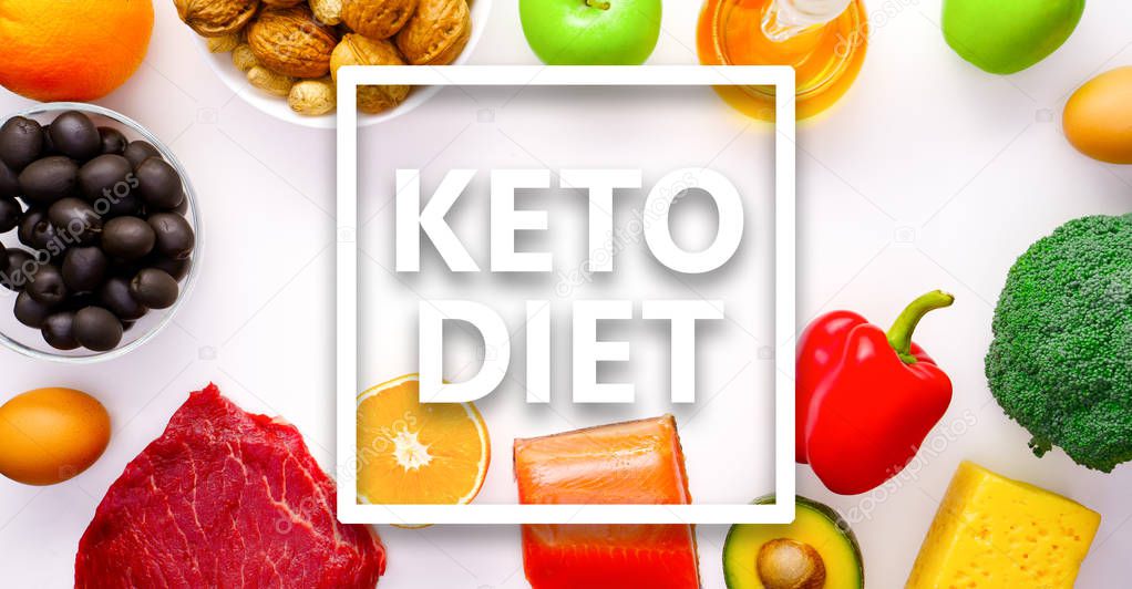 Image on top of piece of meat, fish, cheese, eggs, vegetables, fruits, olives, walnuts on white background.Ingredients for ketogenic diet.