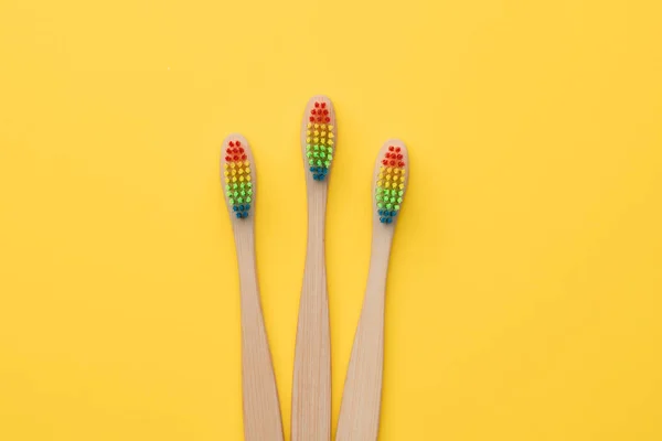 Foto de tres cepillos de dientes con cerdas de color arco iris . —  Fotos de Stock