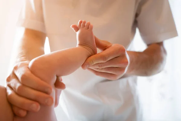 Foto de arriba del bebé recién nacido y manos de masajista masculino . — Foto de Stock