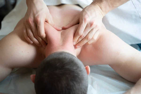Picture of hands masseur doing massage to young male. — Stock Photo, Image