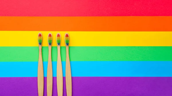 Foto en la parte superior de cuatro cepillos de dientes sobre fondo de arco iris . — Foto de Stock