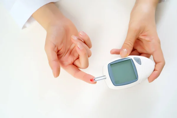 Afbeelding van dames hand met glucometer. — Stockfoto