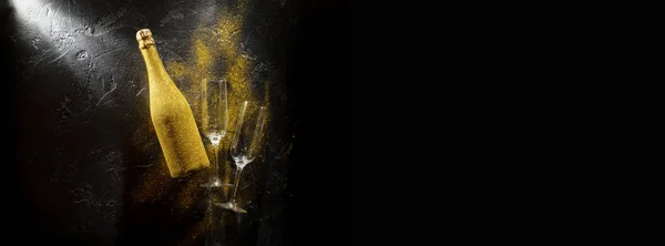 Image of golden champagne bottle, two wine glasses on black stone background — Stock Photo, Image