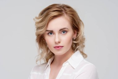 Studio Beyaz gömlekli ciddi kıvırcık kadın portresi.