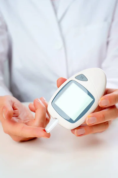 Afbeelding van artsen hand met glucometer. — Stockfoto