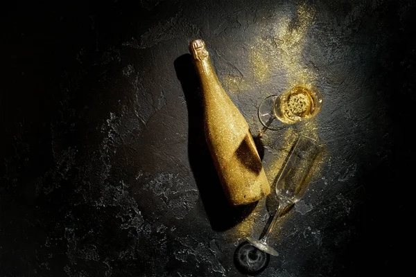 Immagine romantica di bottiglia di champagne d'oro, due bicchieri di vino su sfondo nero — Foto Stock