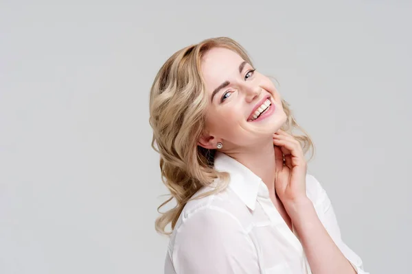 Portrait of smiling curly blonde in white shirt. — Stock Photo, Image