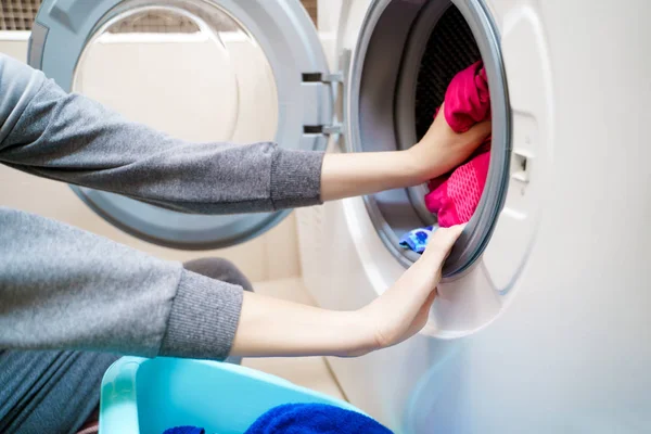 Imagem de mãos de mulher colocando roupas sujas na máquina de lavar roupa . — Fotografia de Stock