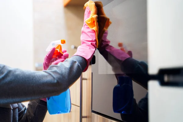 Foto de las manos de mujer en guantes de goma con trapo y detergente limpieza microondas . — Foto de Stock