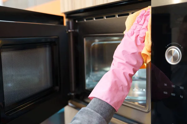 Image of hands in rubber gloves washing microwave — Stock Photo, Image