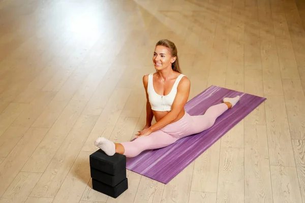 Joven mujer haciendo splits en mat  . —  Fotos de Stock