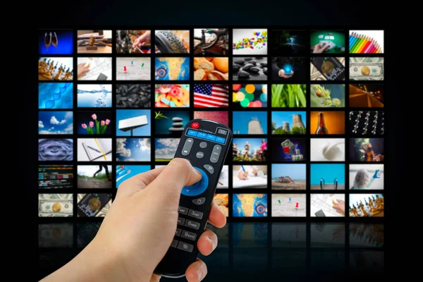 Pantalla de TV con muchas fotos y manos de hombre con control remoto  . — Foto de Stock