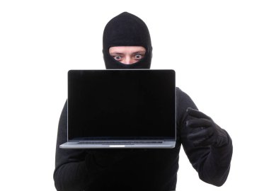 Dizüstü bilgisayar ile siyah maskeli hacker adam elinde boş ekran ile.