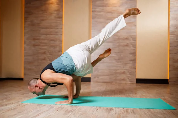 Vuxen man öva yoga stående på blå matta. — Stockfoto