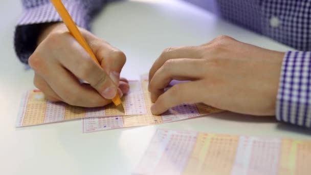 Mans wypełnia ręki bilet loterii przez pen — Wideo stockowe
