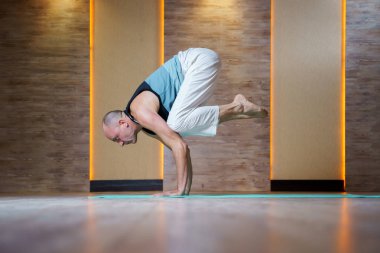 Sportif adam dururken elleri mavi mat yoga uygulamaları.