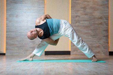 Sportif adam ile seyir spor salonunda mavi mat yoga yaparken Kol kaldırdı.