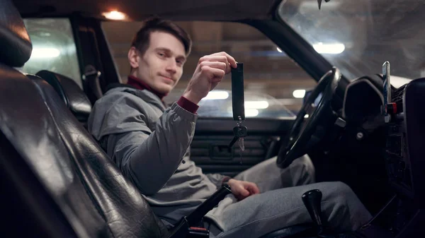 Foto do lado do motorista masculino segurando as teclas sentadas no carro . — Fotografia de Stock