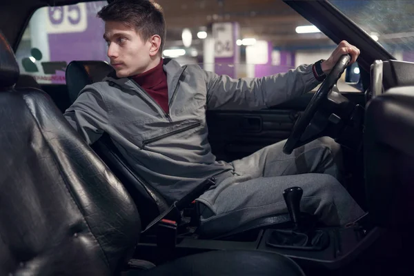 Foto de lado del conductor masculino mirando hacia atrás mientras está sentado en el coche  . —  Fotos de Stock