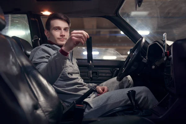 Foto di lato dell'uomo conducente che tiene le chiavi seduto in auto  . — Foto Stock