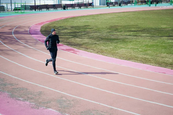 运动员在春季慢跑时跑过体育场的照片. — 图库照片