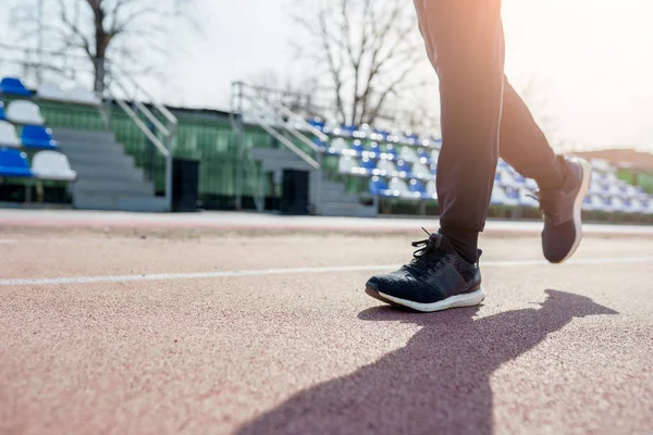 Foto von der Seite der Beine des Athleten, der durch das Stadion läuft — Stockfoto