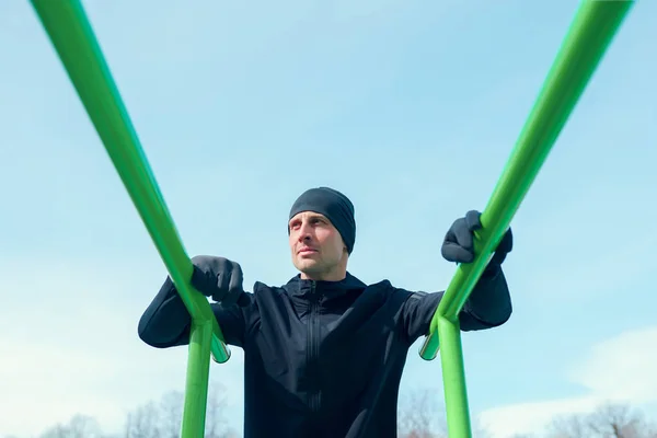 Foto van atleet trekken omhoog op groene rekstok — Stockfoto