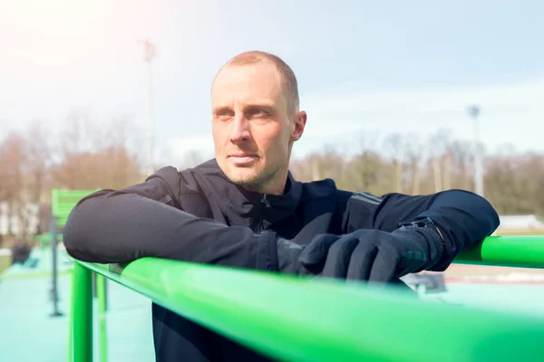 Foto del deportista tirando hacia arriba en la barra horizontal verde — Foto de Stock