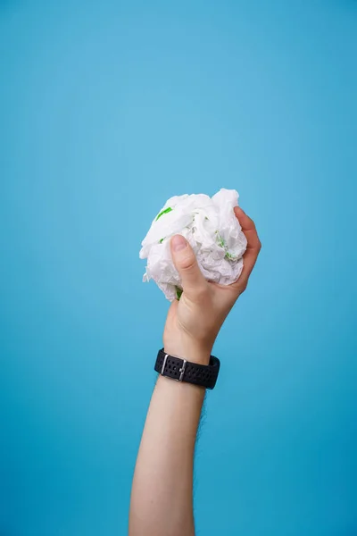 Hand hält Plastiktüte vor blauem Hintergrund. — Stockfoto