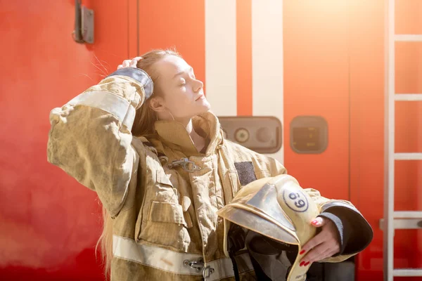 Imagen en el lado del fuego mujer rubia de pie cerca de camión de bomberos — Foto de Stock