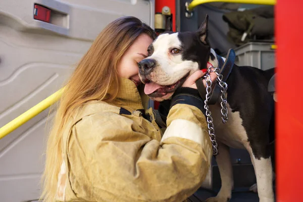 Image de pompier avec chien debout près du camion de pompiers à la station — Photo