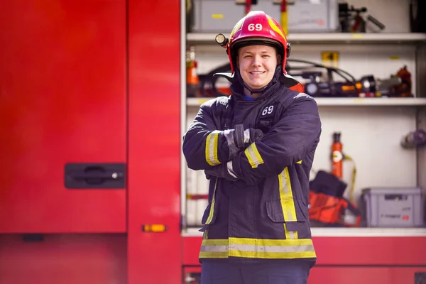 Obraz požárního bojovníka v helmici na pozadí hasičáku — Stock fotografie