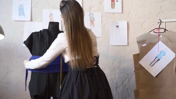 Женщина-модельер одевает маникена в студию моды — стоковое видео