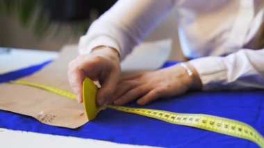 Kumaş üzerinde bir kadın terzi çizim şablonu ellerine yakın