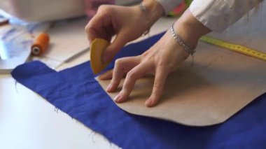 Kumaş üzerinde bir kadın terzi çizim şablonu ellerine yakın