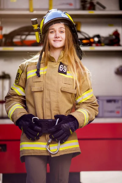 Imagen de mujer bombero en casco de pie cerca de camión de bomberos — Foto de Stock