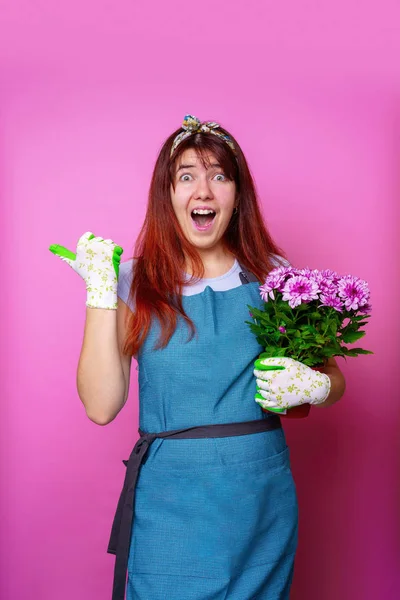 Photo of happy girl with chrysanthemum pointing hand to side — Stock Photo, Image