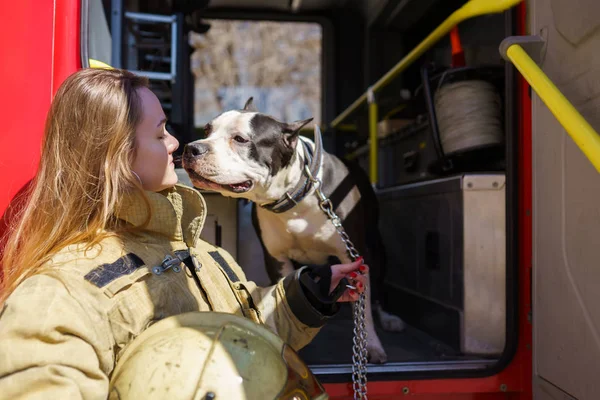 Photo of firewoman with dog standing near fire truck — Stock Photo, Image