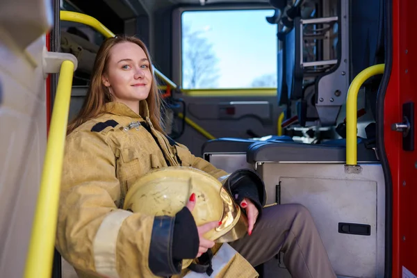 Foto de la mujer feliz fuego de pie en camión de bomberos — Foto de Stock