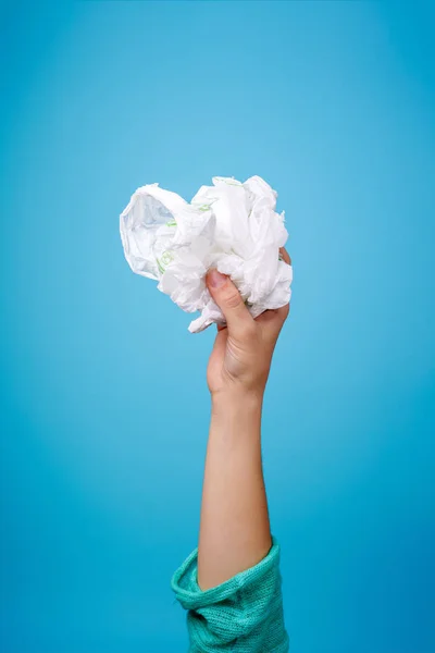 Hand holding plastic bag against blue background. — Stock Photo, Image