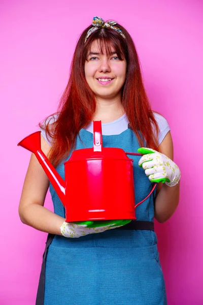 Foto de mujer morena florista feliz con regadera en la mano — Foto de Stock