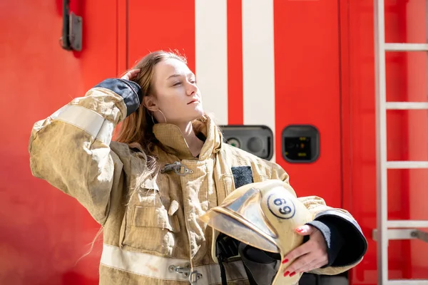 Foto an der Seite von Feuerwehrfrau, die in der Nähe eines Feuerwehrfahrzeugs steht — Stockfoto
