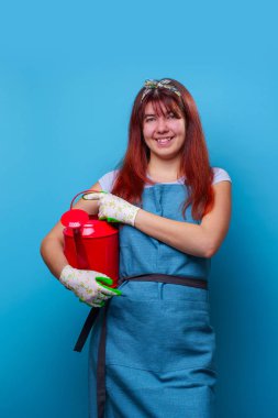 Yan parmak işaret elinde sulama ile gülümseyen kız çiçekçi Fotoğrafı