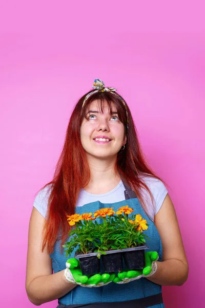 Foto de una mujer feliz mirando hacia arriba con caléndulas en sus manos — Foto de Stock