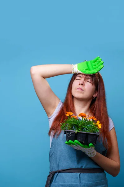 Foto de chica morena cansada con caléndulas en las manos — Foto de Stock