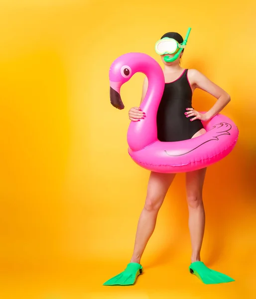 Foto de cuerpo entero de chica en traje de baño con boya salvavidas y aletas sobre fondo naranja vacío — Foto de Stock