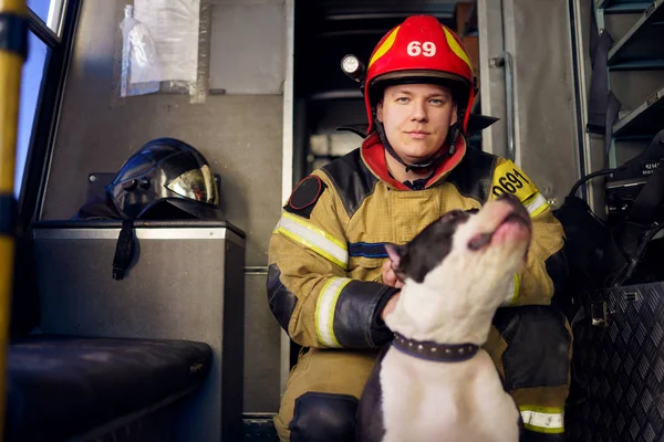 Foto do homem bombeiro com cão salva-vidas — Fotografia de Stock