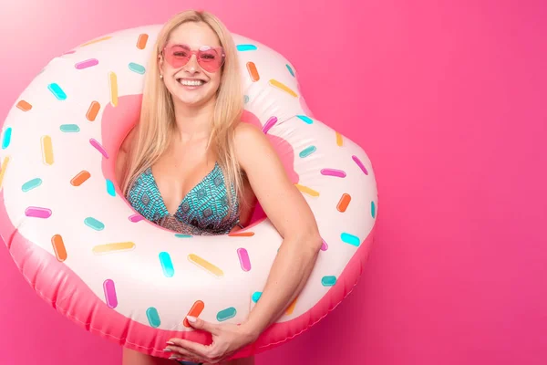 Imagen de chica rubia feliz en gafas de sol de traje de baño con rosquilla inflable para nadar — Foto de Stock