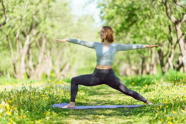 Образ спортивної жінки, що робить йогу в лісі — стокове фото