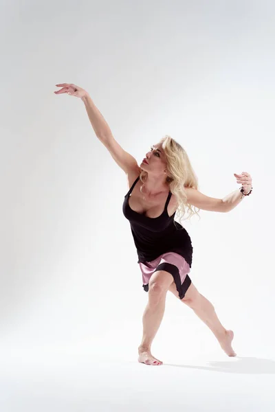 Foto de larga duración de una chica rubia bailando en un estudio vacío — Foto de Stock
